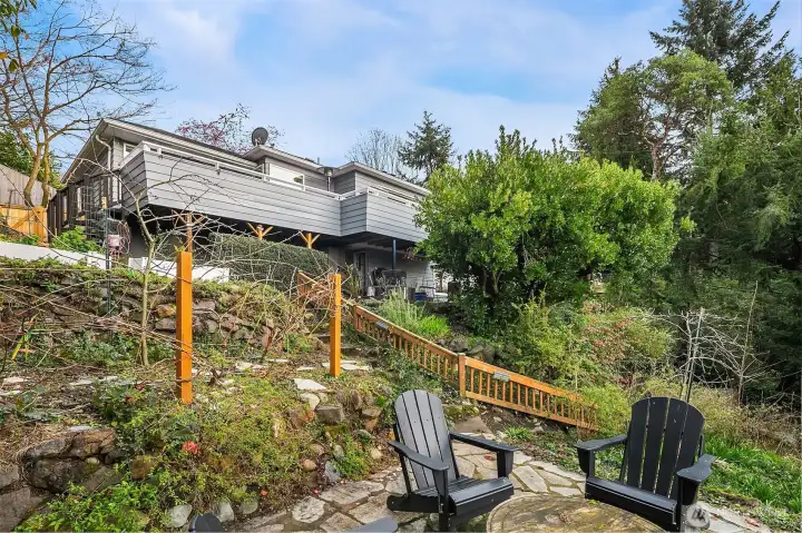 The landscaping blends natural vegetation with intentional plantings: Fig and apple trees, raspberries, elderberries and clusters of champagne grapes.