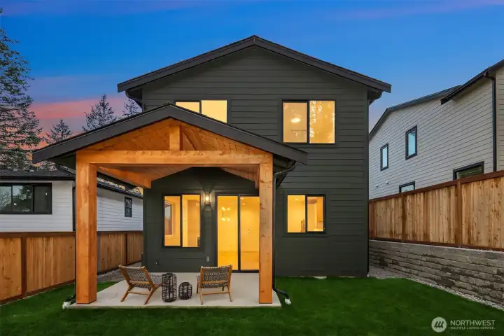 Covered patio and flat, fully fenced backyard with irrigation system