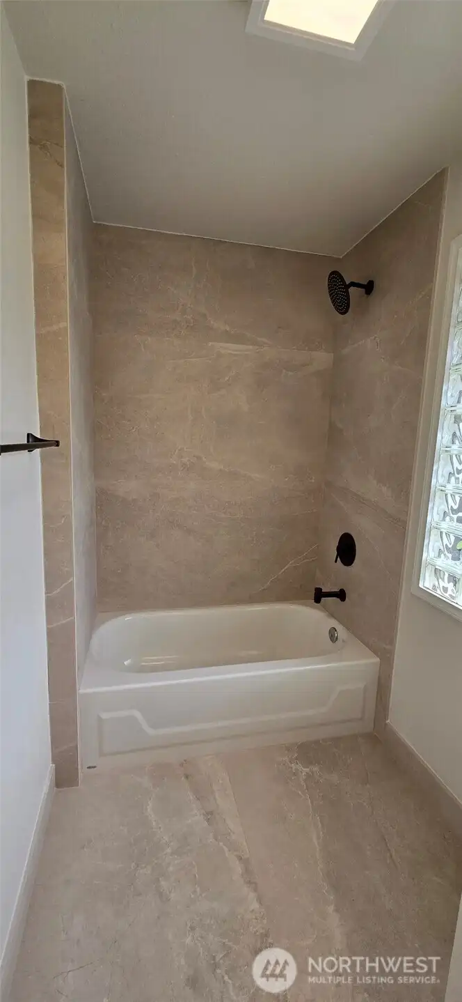 Beautiful new tile work like this in the upstairs bathroom, can be see throughout the home.