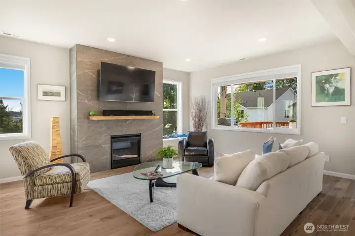 Open concept floor plan with custom tile fireplace and live edge cedar mantle. One of many custom upgrades in this home.