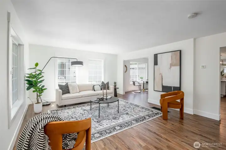 The living room has big windows and is full of light.