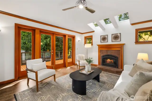 Family room features skylights and an elegant fireplace and open effortlessly onto outdoor deck for al fresco living