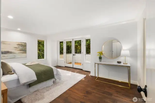 The expansive primary suite also features French doors out to the wrap around deck outside