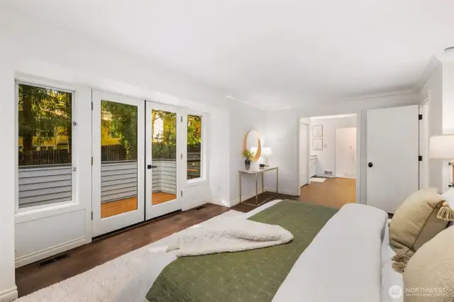 The expansive primary suite also features French doors out to the wrap around deck outside