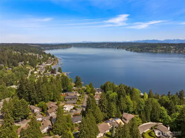 This stunning lake view serves as the backdrop for the living room, kitchen, and expansive wraparound front deck, offering serene scenery from every angle.