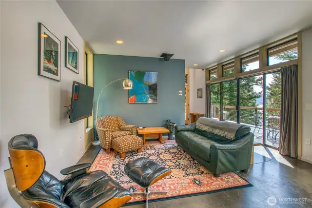 The living area is by a patio door leading to the large deck. There is a chimney if you wanted to replace the wood burning stove.