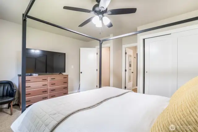 Spacious primary bedroom with cooling ceiling fan