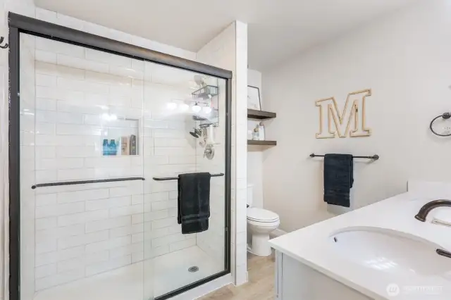Primary bathroom. Shower w/glass doors and subway tile.