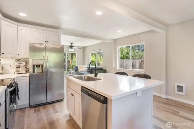 Cooks kitchen features white cabinets, tile backsplash and soft close drawers.