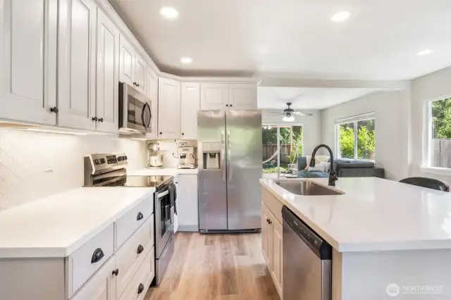 The kitchen is the heart of the home and looks out to the family room toward the backyard and the dining area to the front. So much natural light.