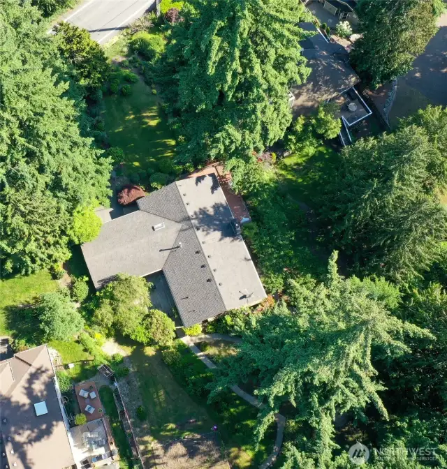 Aerial view of home and lot. Some level lot in front yard, and in back yard with garden area. Other areas are sloped