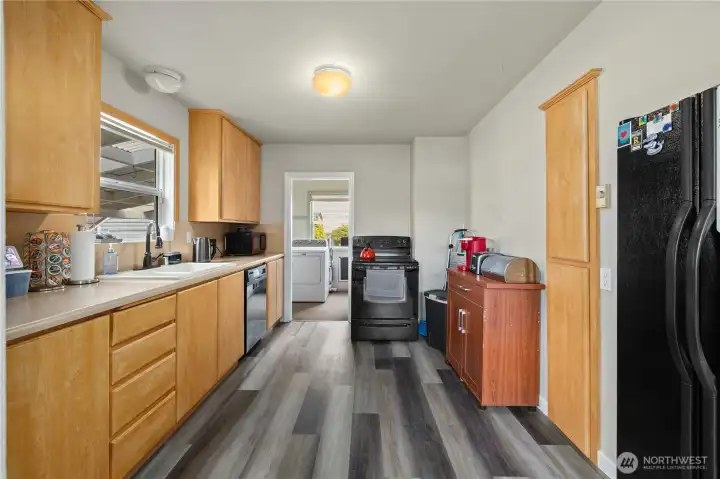 Bright kitchen featuring functional layout, durable laminate flooring, and fresh paint.