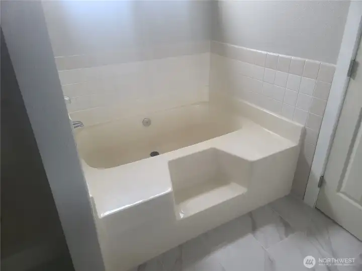 Large soaking tub in the Primary bedroom  bath with separate shower to the left