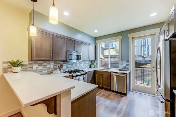 Kitchen area with eating bar, stainless appliance gas stove
