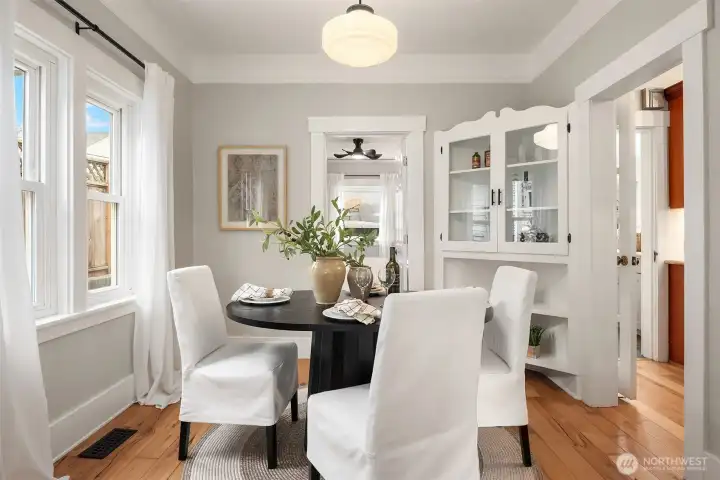 Welcoming formal dining room features original, built-in china hutch, new windows and updated period lighting.