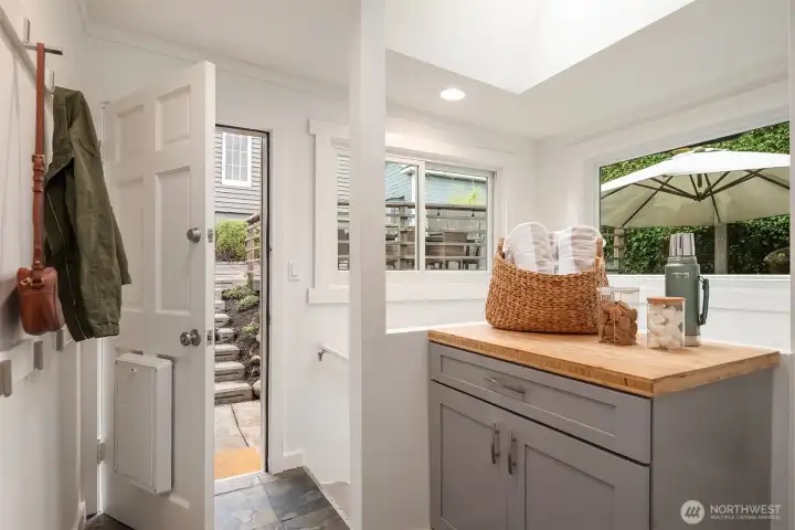 Tiled mudroom offers storage, new windows and access to basement, back yard and kitchen.