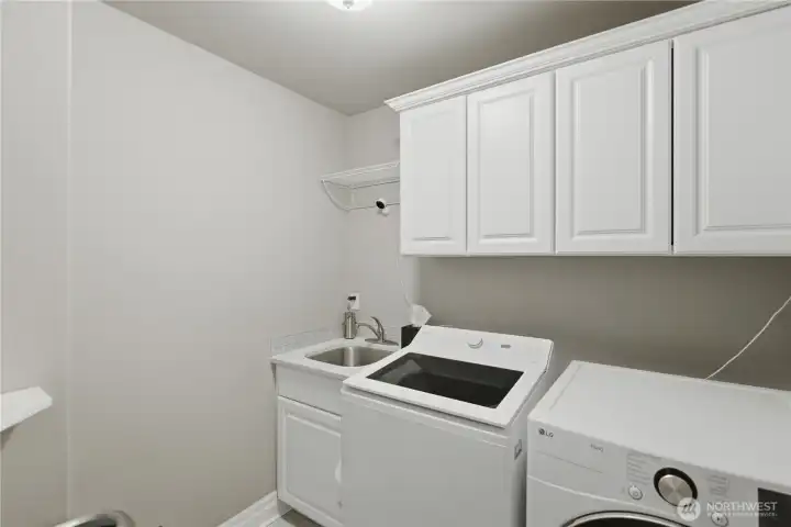 Laundry room with storage and utility sink.