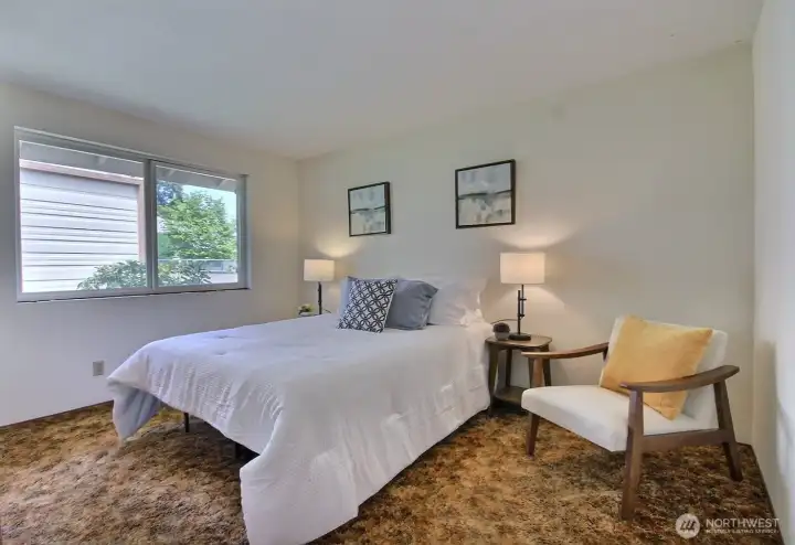 The spacious primary bedroom is located at the end of the hall and overlooks the backyard.