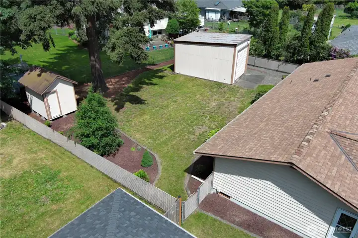 Sun filled fully fenced levle backyard has garden shed and additional garage/shop.