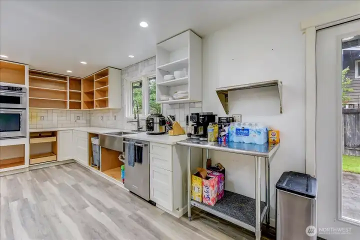 Modern kitchen featuring stainless steel appliances and a farmhouse-style sink.