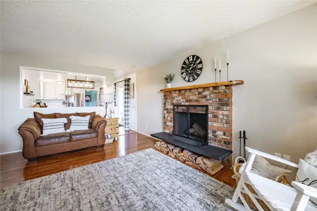 Living Room with wood Fireplace and looks back into dining and kitchen