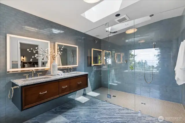 The spa-inspired primary bath is a serene retreat, showcasing Robern Uplift medicine cabinets with sleek vertical lift doors, integrated lighting, and built-in outlets—pairing modern design with everyday convenience.
