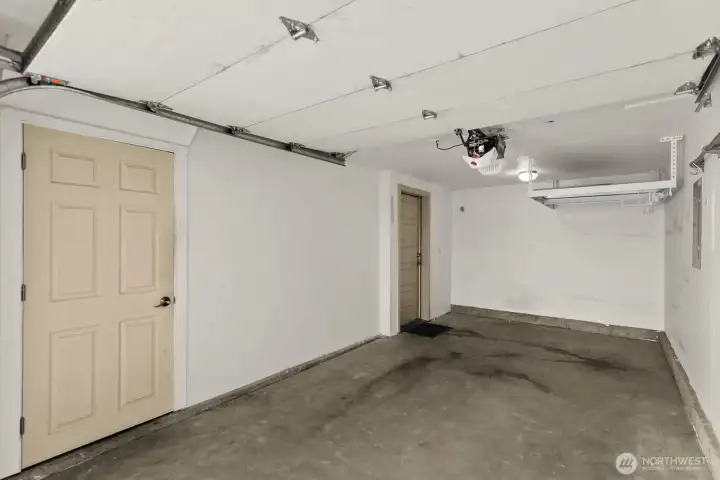 One car garage with storage closet and overhead shelving.