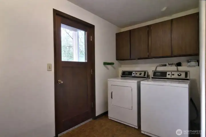 Lower level utility room includes Speed Queen washer and dryer and has convenient backyard access.