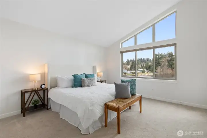 Primary bedroom with vaulted ceiling capturing tons of natural light from the lake.