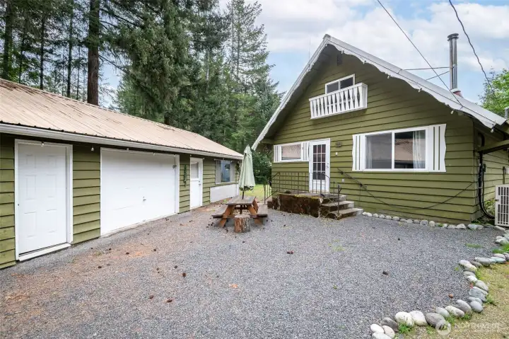 View of the front courtyard featuring a picnic table, string lights, and easy access to both the house, garage, and bonus rec room.