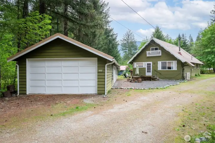 A long private driveway leads to the charming green house and oversized three-car garage nestled among the trees.