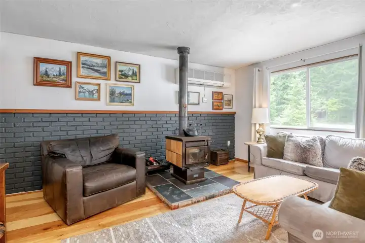 Wood stove features decorative vintage tile and is set on a slate hearth.