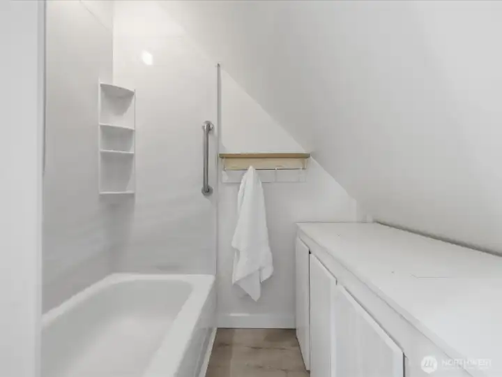 The upper level full bathroom with linen storage cabinet.