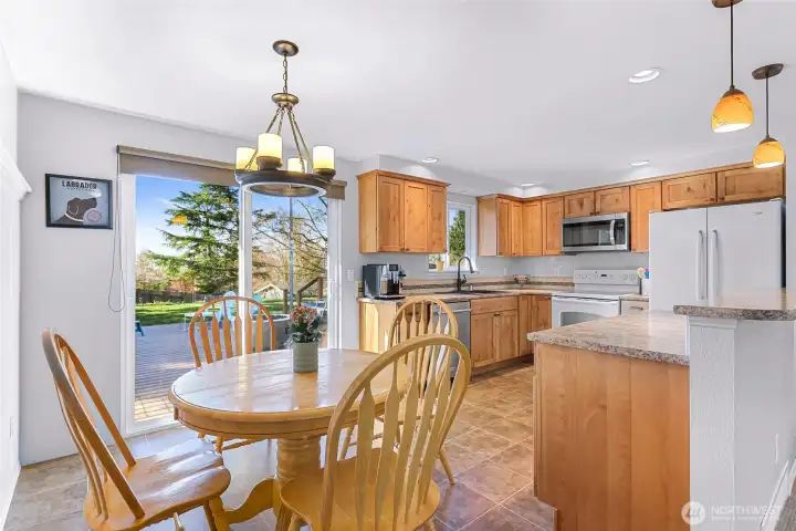 Dining area extends through sliding door and opens to expansive deck