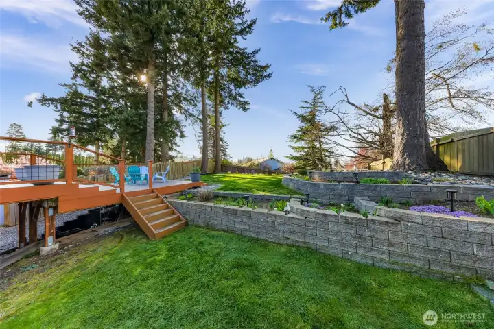 Access from main deck to lower level of yard, professional hardscape wall. Sneak peek of the storage area under the deck that is water sealed to keep your outdoor items safe and dry!