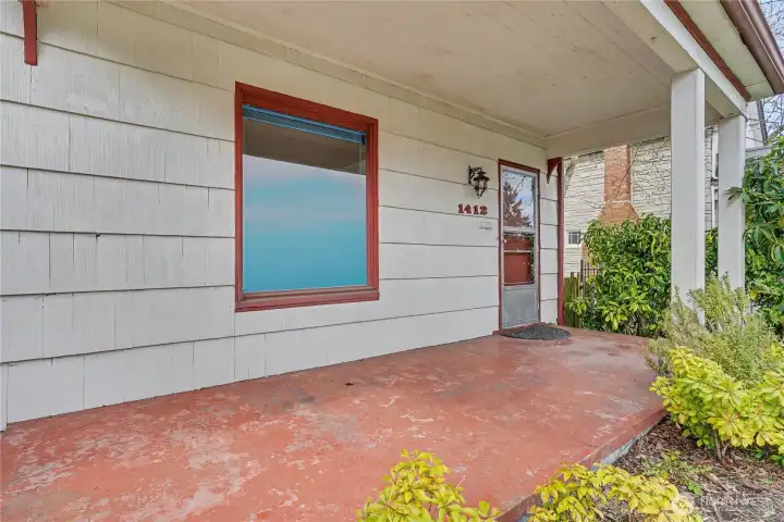 Covered front porch providing a welcoming entry and a glimpse into the home’s long-preserved charm.