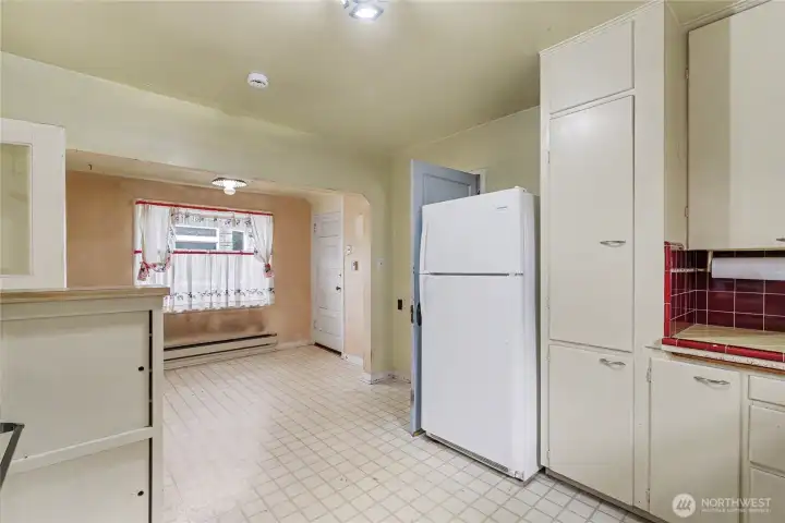 Kitchen area featuring vintage cabinets, classic tile accents, and a cozy breakfast nook, providing a solid foundation for updates while retaining nostalgic appeal.