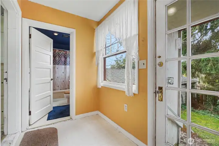 Practical back entry with direct yard access and an adjacent full bathroom, offering a convenient layout ready for modernization.