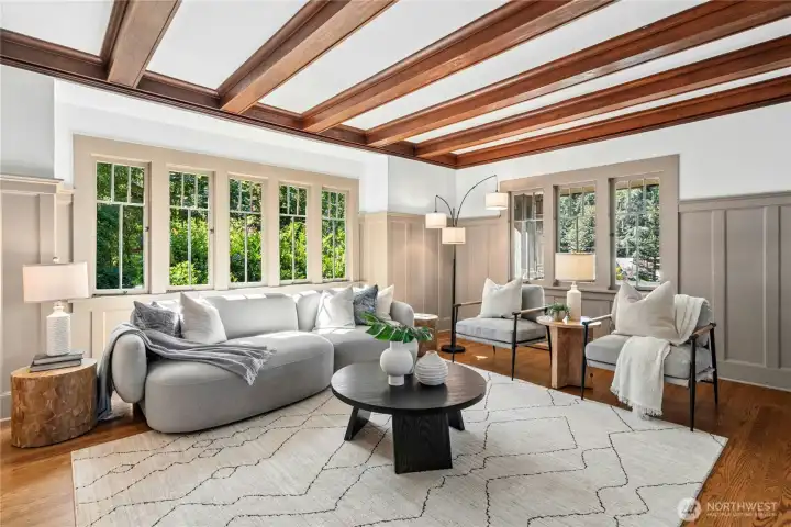 This living room has everything going for it-countless original windows, gleaming box beam ceilings.