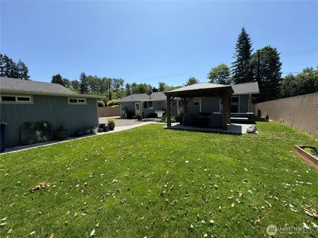 There is a welcoming back yard with a raised flower bed (to right of photo) . See the beautiful Gazebo? The concrete detached blocks will stay if requested (under gazebo)....the large rose quarts rock is personal and will not stay, is property as well as the patio furniture. but you can see how wonderful you can make this your own...