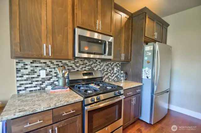 Kitchen features granite countertops, glass tile backsplash, stainless steel appliances.