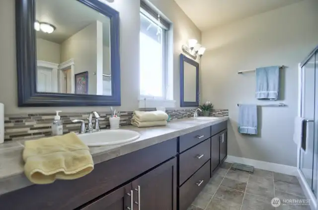 Double sinks, walk in shower with glass front, plenty of storage, tile counters.