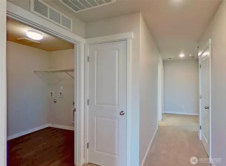 Laundry room and hallway to additional bedrooms.