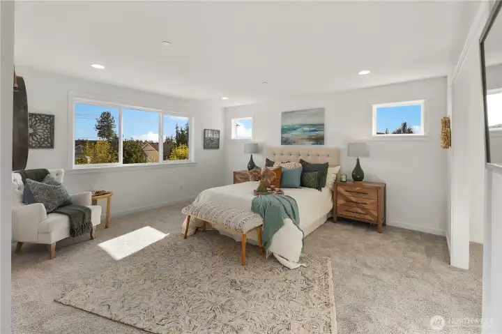 Primary Suite  The primary bedroom offers a spacious retreat with expansive windows that draw in natural light and frame neighborhood views. Soft carpeting underfoot enhances comfort, while the thoughtful layout allows for flexible furniture placement and a dedicated sitting area. Clean lines and neutral tones create a calm, cohesive atmosphere.    Located in Bothell near Canyon Park conveniences, this private retreat reflects the elevated standards associated with luxury new construction in Bothell. The well-proportioned design supports everyday comfort within a contemporary home situated in the Northshore School District.    These photos are from a past Robinson Plan at a different community, so overall plan, colors, building orientation, finishes, home outlook, and other details can and WILL vary. All photos, renderings, site maps, and floorplans are for visualization purposes only.