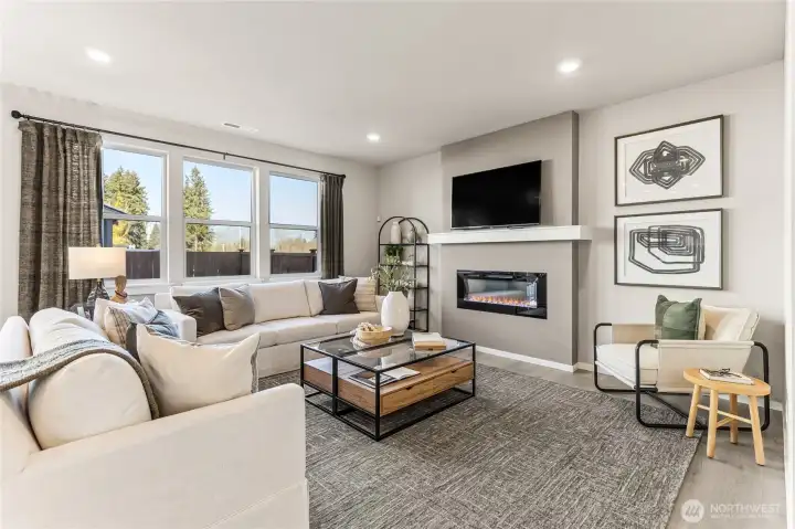 Cozy living room featuring an electric fireplace as the focal point, perfect for relaxing evenings at home. Photos are representative only and may display different color package and/or upgrades.