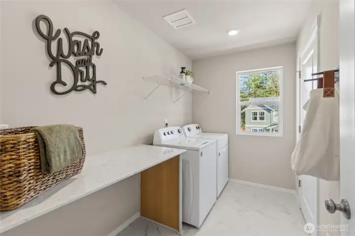 Well-appointed laundry area with thoughtful design details throughout such as the large laundry folding tabe with area for hampers. Photos are representative only and may display different color package and/or upgrades.
