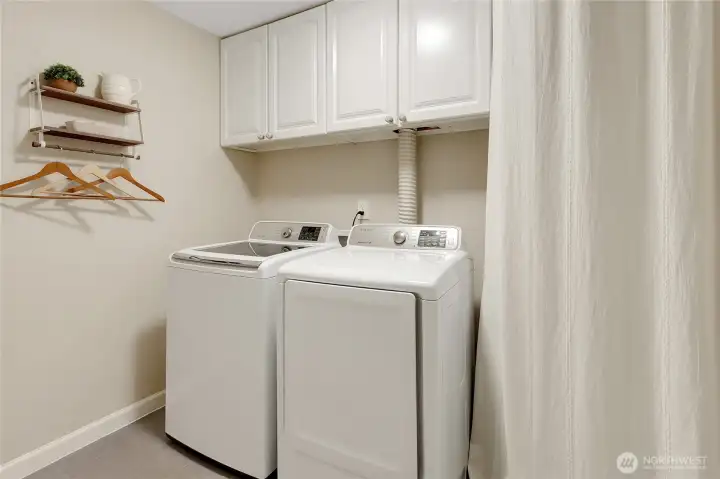 Laundry room has everything you need, storage space, shelves and both washer and dryer convey with the property!