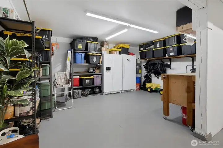 Spacious garage, recently coated flooring, refrigerator stays with the property, plenty of great lighting in here and storage as well!