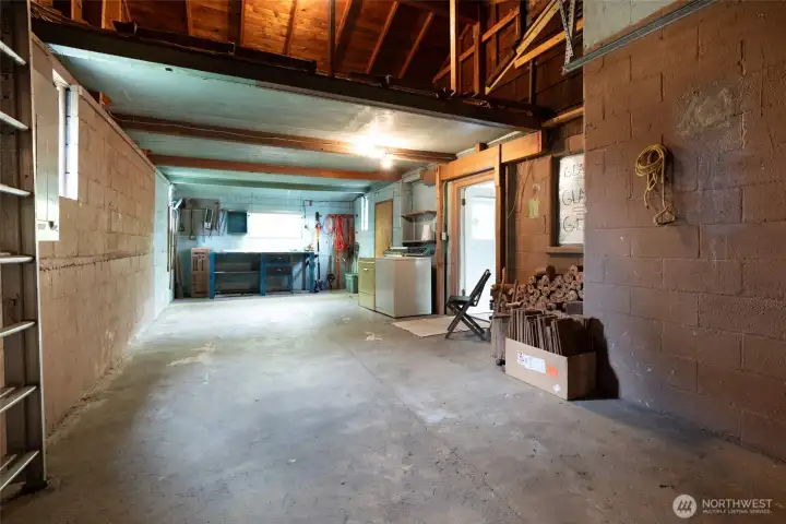 Roomy garage with work bench, storage & washer & dryer