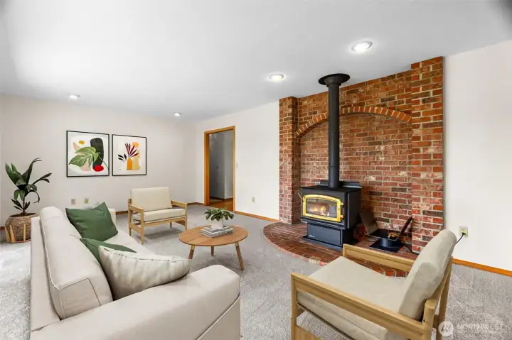 It's cozy around the wood stove in the family room (virtually staged).